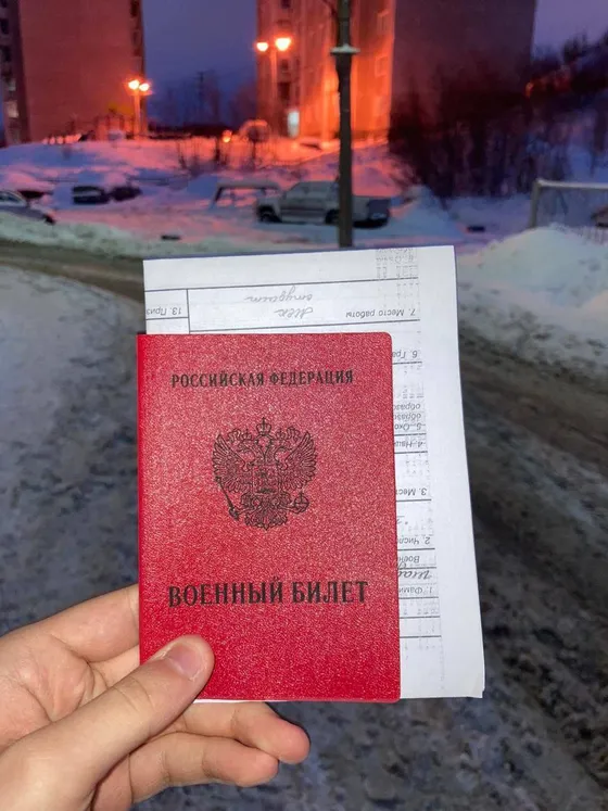 Призывник демонстрирует военный билет после консультации